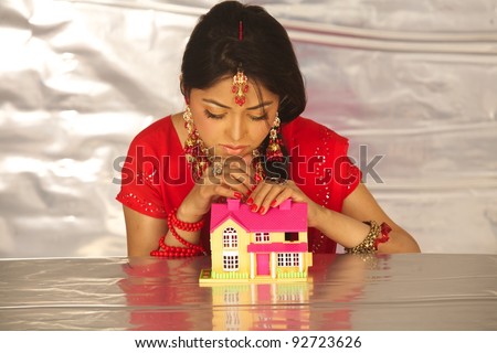 Young beautiful Indian business woman with house model - real estate