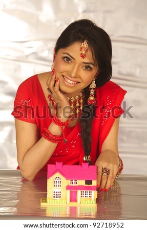 Young beautiful Indian business woman with house model - real estate