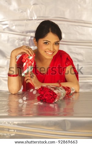 Indian  woman with gift box and flowers . Isolated