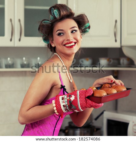 Young attractive girl in beautiful clothes bakes cakes. Pin-up style images. grain added