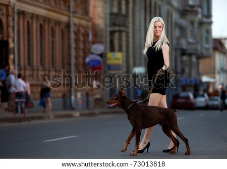 Portrait of beautiful young woman walking a dog