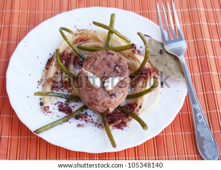 Appetizing chopped meat cutlet with a spaghetti and fried garlic in spicy spices