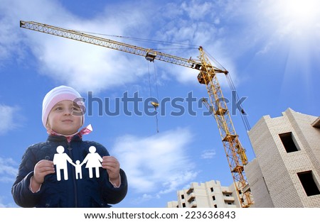 Happy little girl with paper family in hands.Construction new home for young family