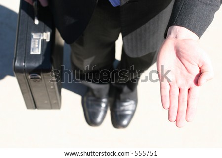Man in suit with a briefcase, extends the palm of his hand, ready to accept the offer