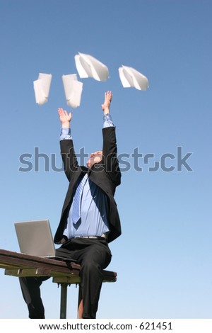 businessman throws papers in the air in celebration