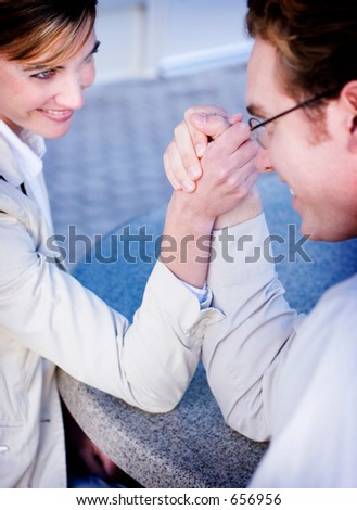 Business man and woman arm wrestling