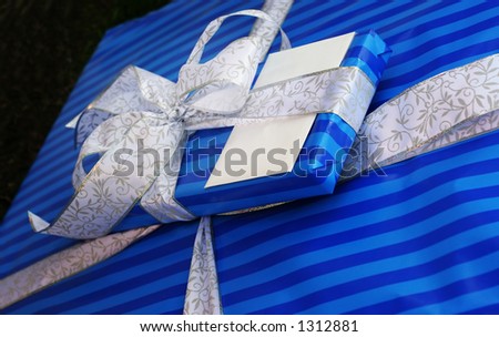 Two presents wrapped with blue paper and lace