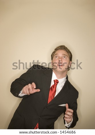 Business man in white shirt, black suit, and red tie is posing a scared expression