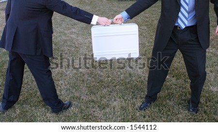 Two businessmen struggle over briefcase in the green grass