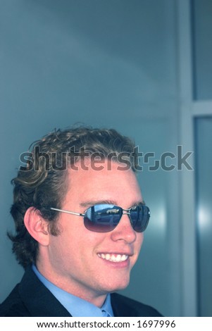 Business man wearing blue shirt and blue tie is wearing sunglasses