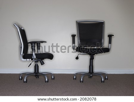 One business chair is facing and looking at the taller, more confident business chair, which is the boss