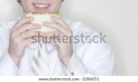 Businessman getting ready to take a bite of his lunch eating a sandwhich