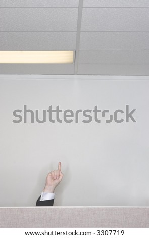 Businessman raises his hand and finger up in the air behind his cubicle in the office