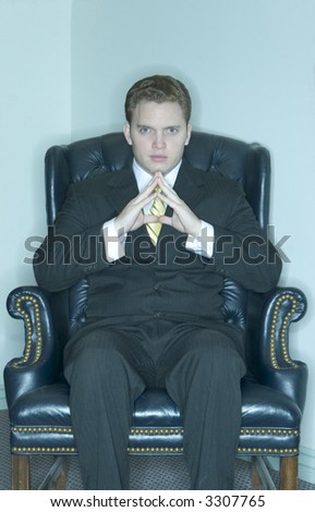 Businessman sitting in his chair with his hands coming together as a sign of his power and understanding
