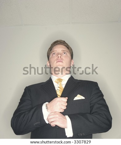 Businessman gets his shirt and cuffs ready in order to move ahead while wearing a black suit and looking forward