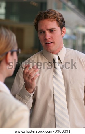 Business people talking outside during a break while wearing tan business clothes