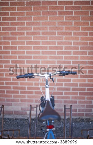 over head image of a bike in a bike rack against a brick wall