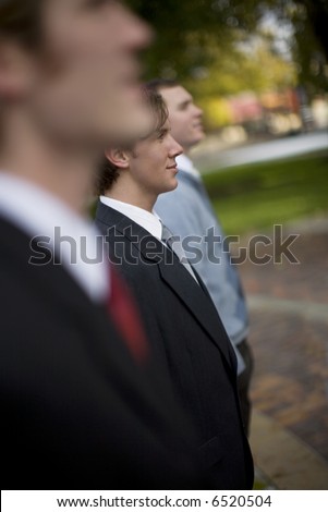 three business people in a row standing profile shot