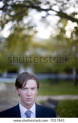head and shoulders shot of brown hair blue eye young businessman looking at camera