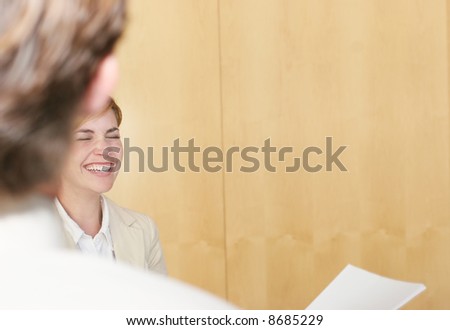 two business people standing talking and laughing