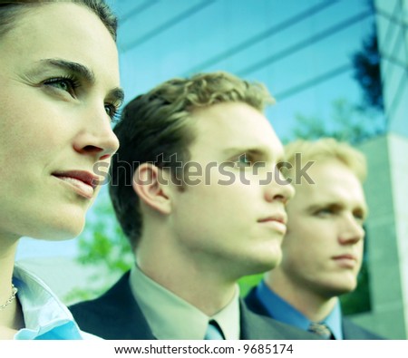 three businesspeople standing facing  same direction