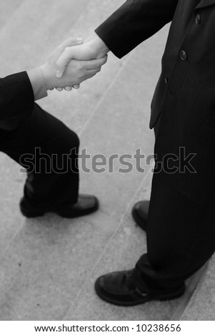 Businessman Gives a Handshake while he\'s stepping forward