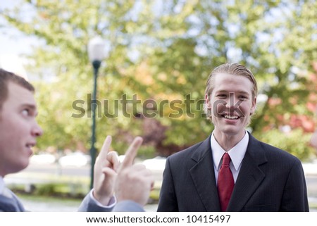 side view of businessman talking with another businessman who is laughing