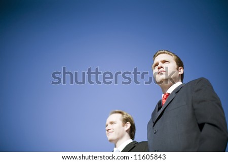 Two businessmen wearing suits posing with determined vision pose