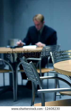 Businessman wearing suit sitting down at table crunching the numbers