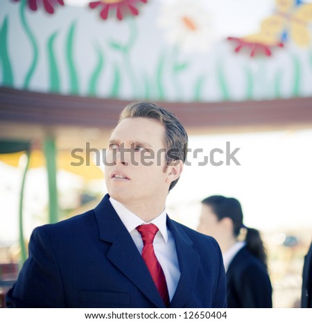 Business people standing wearing suits with one businessman looking away with worried look