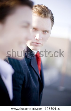 handsome businessman looking at camera while businesswoman looks forward