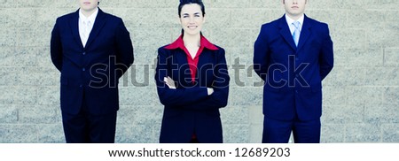 Powerful businesswoman stands between two businessmen