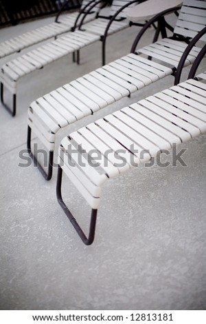 a group of pool chairs outside next to the pool in the summer