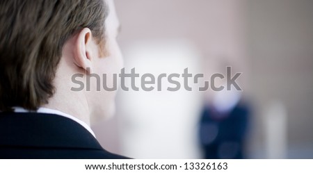 back of the head of a businessman looking at another businessman