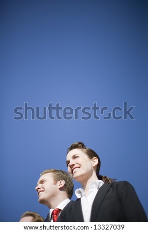 businesspeople standing in line wearing formal clothing and smiling