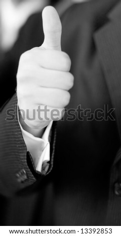 close up of businessman wearing suit giving thumbs up