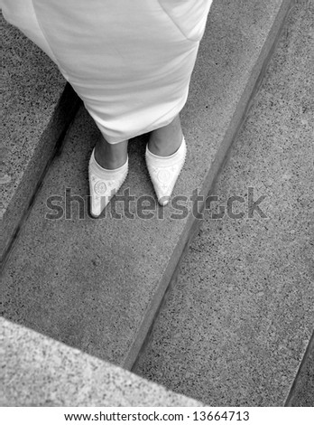 woman wearing wedding dress standing on granite steps