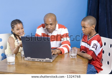 Father and his children play with PC
