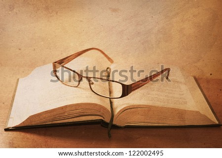 old book with reading glasses