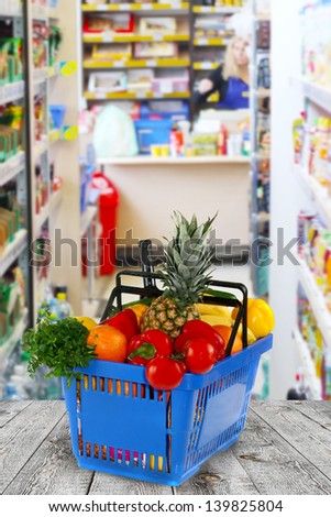 Shopping basket with groceries  on shop of background