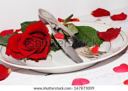 Romantic table setting  with roses plates and cutlery