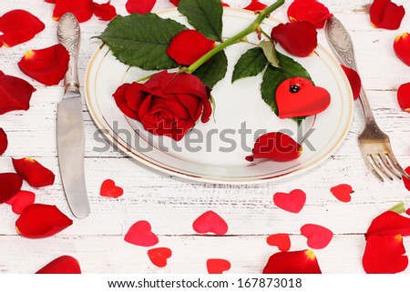 Romantic table setting  with roses plates and cutlery