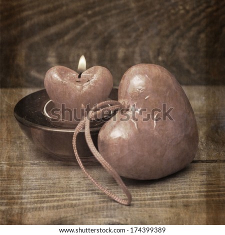 burning candle heart on vintage wooden background
