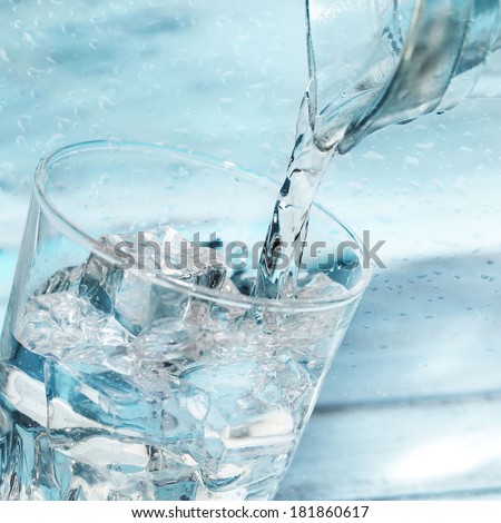 Water poured from a jug into a glass Water poured from a jug into a glass