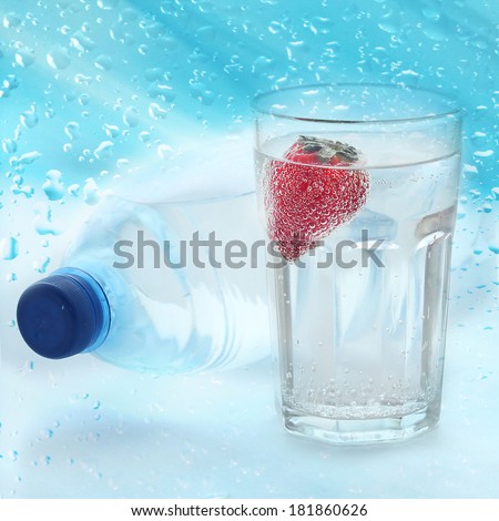 Mineral water in plastic bottle with glass and strawberry