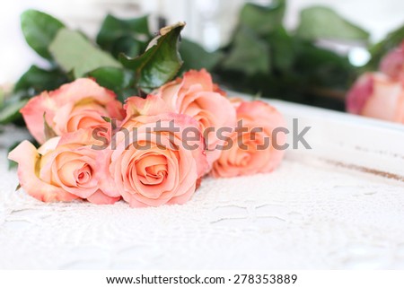Beautiful bouquet of peach roses in shabby style on a mirror background