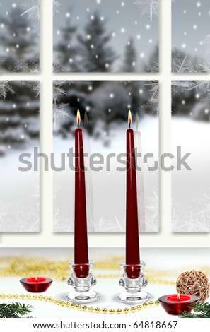 Christmas candles in the window with snowy scene in background