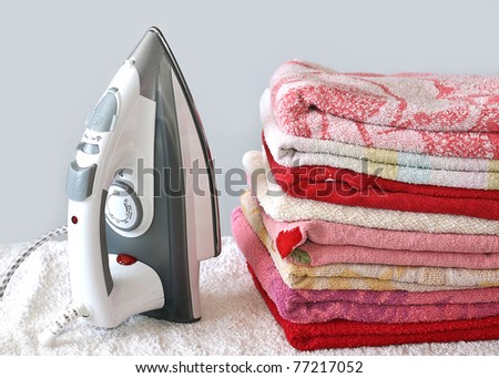 Pile of colorful clothes and electric iron