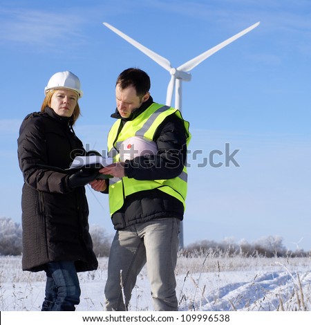 team of  engineers or architects with white safety hat and wind turbines on background