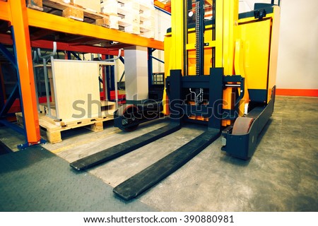 Shelves, racks and forklift  with pallets in distribution warehouse interior